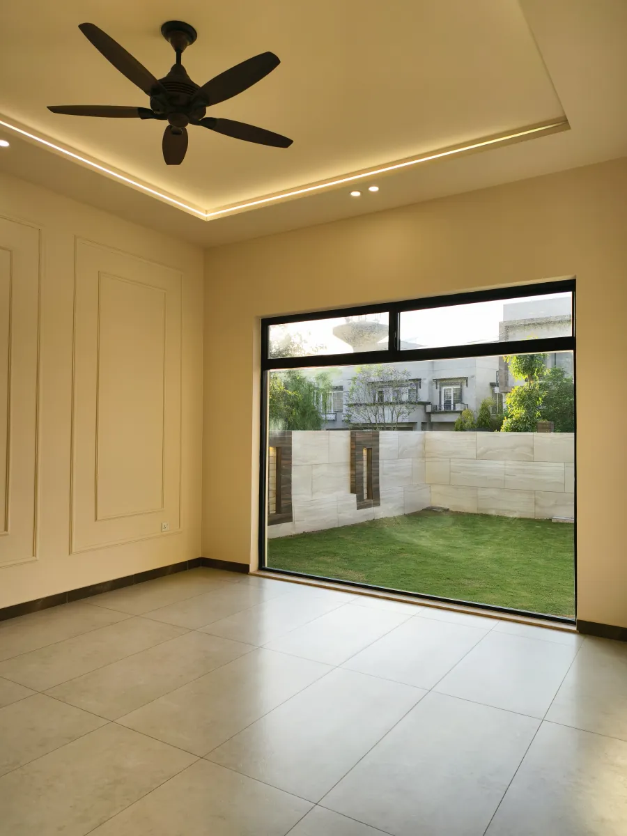 Bedroom opening to the lawn through full-height sliding glass